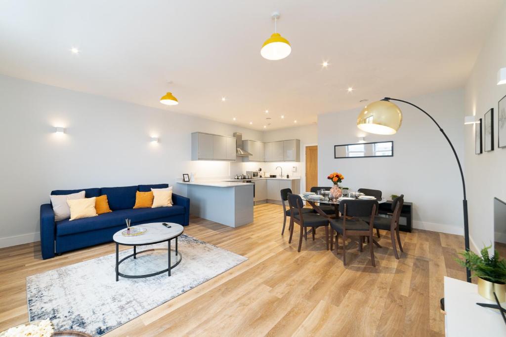 uma sala de estar com um sofá azul e uma mesa em Luxury 2 bedroom flat in Wimbledon Village - walking distance from the tennis courts em Londres