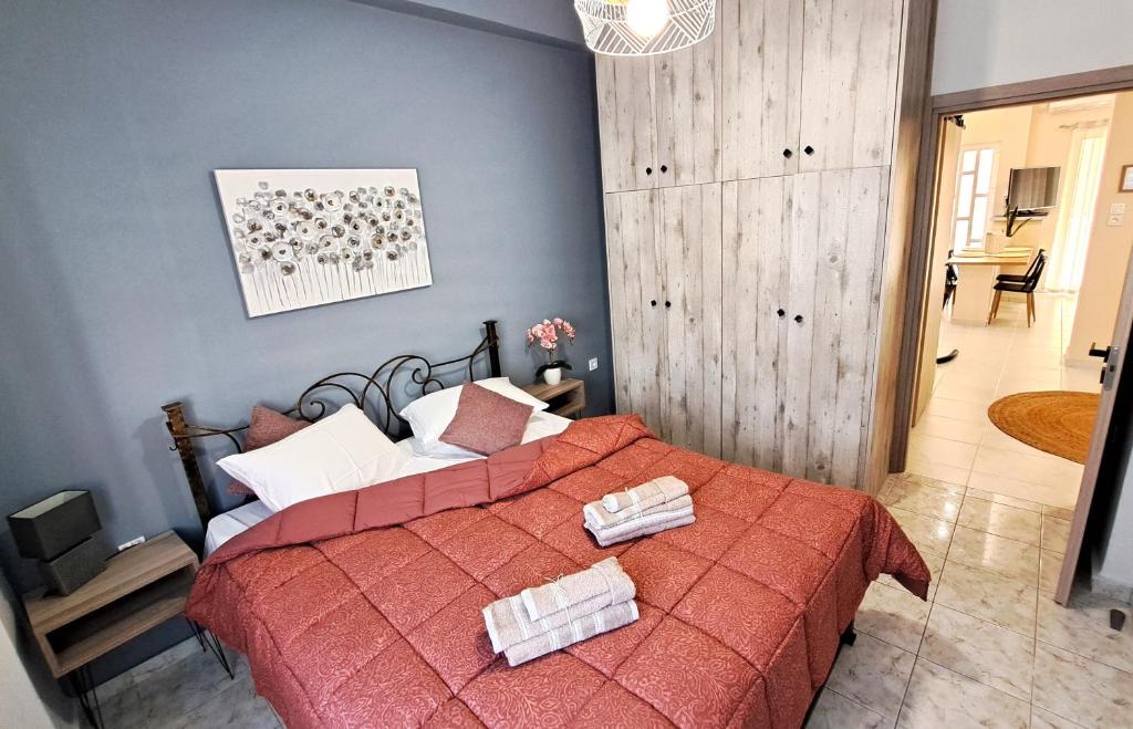 ein Schlafzimmer mit einem roten Bett mit Handtüchern darauf in der Unterkunft Poppys home in Piräus