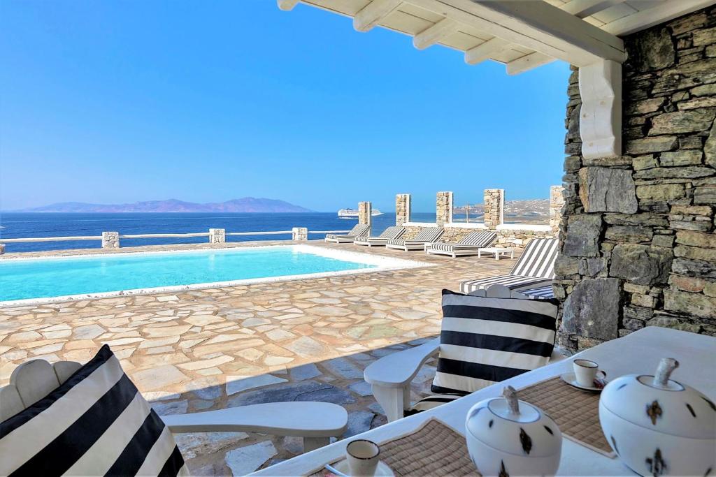 a villa with a pool and a table and chairs at MichaelAngelo Villa in Mýkonos City