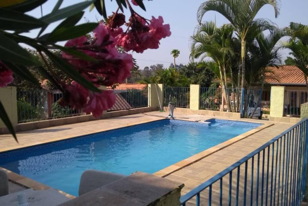 uma piscina com cerca e flores roxas em Chacara muito bonita região de Limeira - Sp em Limeira
