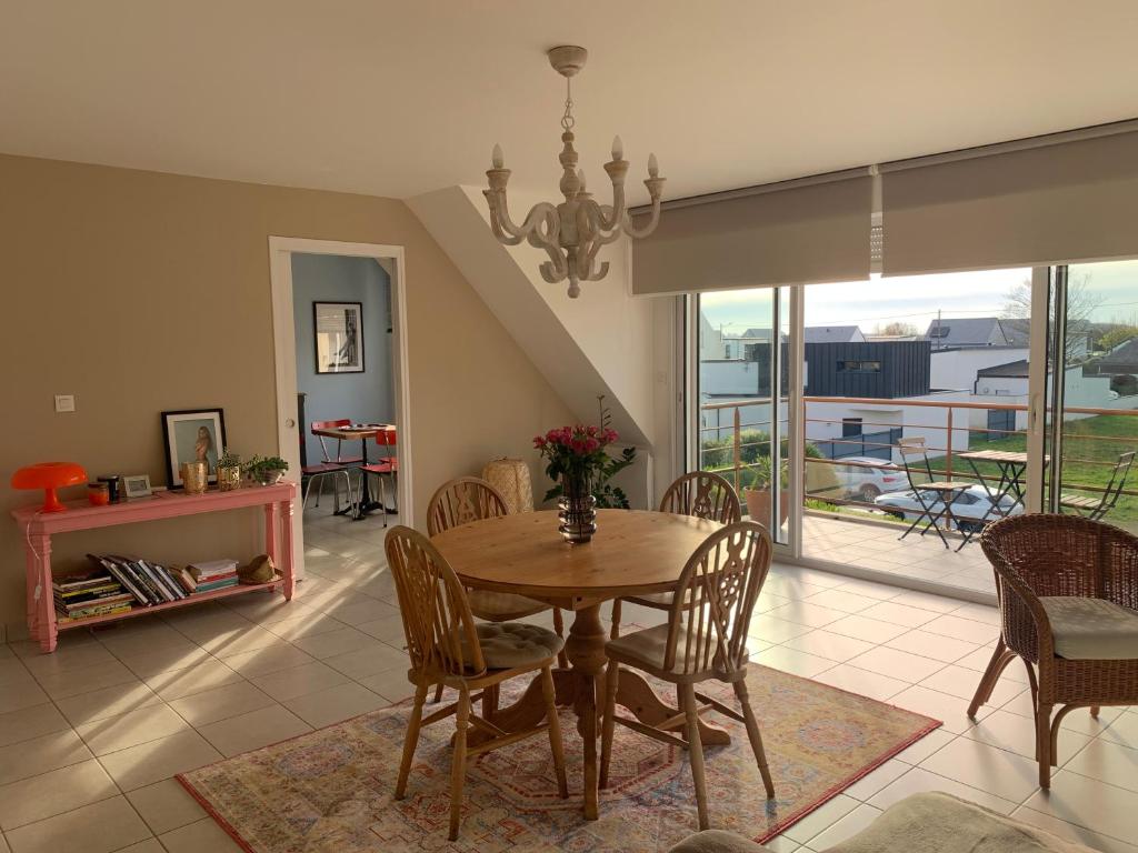 une salle à manger avec une table et des chaises et un balcon dans l'établissement Villa les Agapanthes, à Carantec