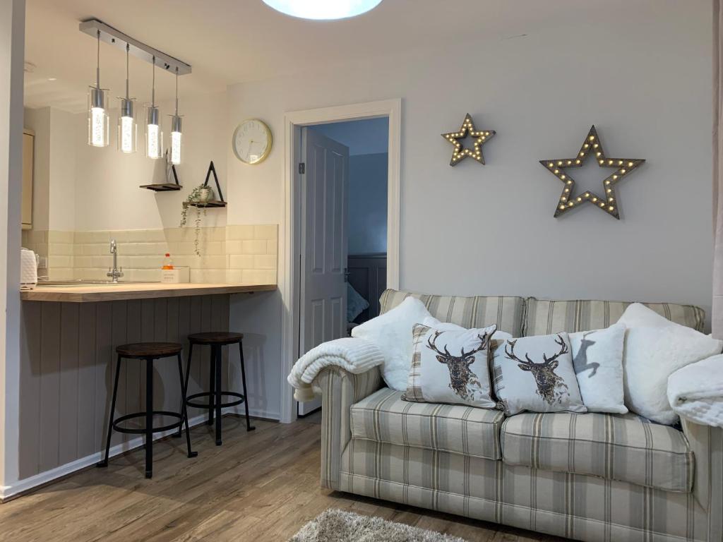 een woonkamer met een bank en een keuken bij SUNNY RHYL BUNGALOW in Rhyl