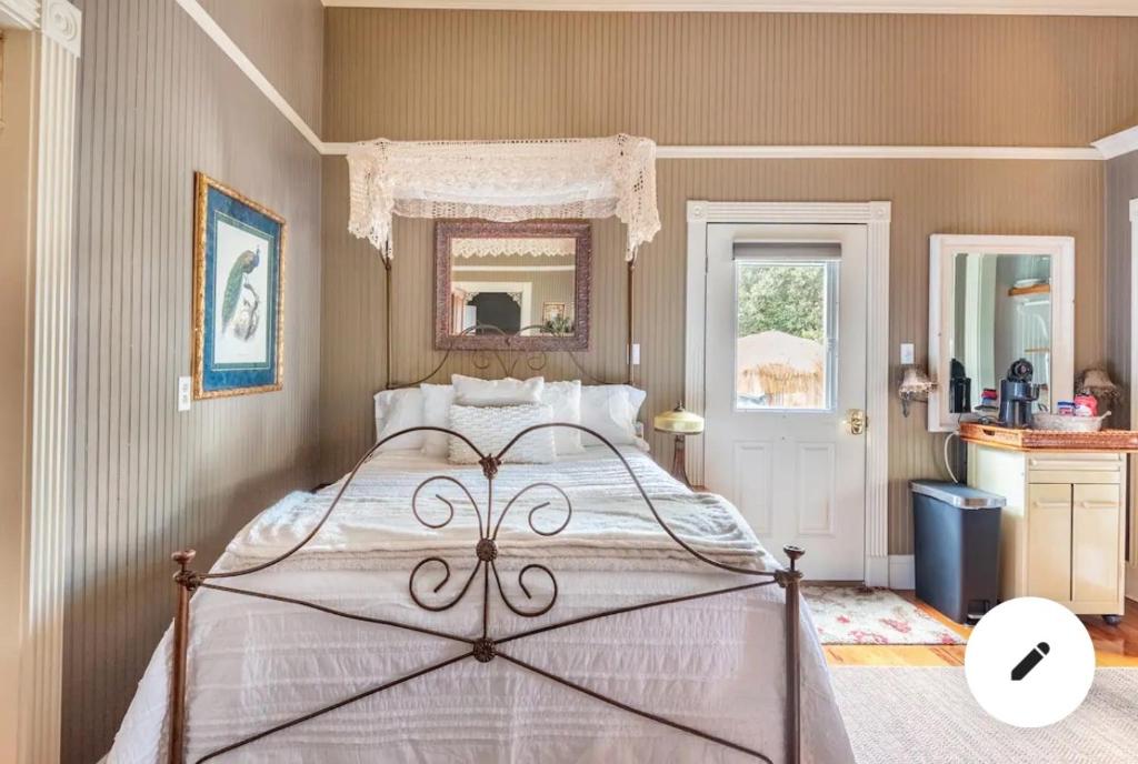 a bedroom with a large bed and a mirror at The Guest Room in Abbeville