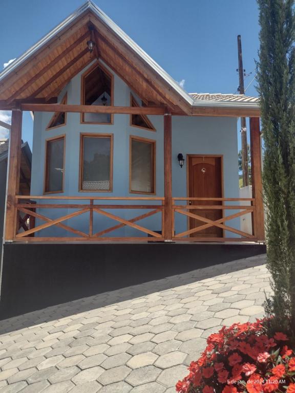 ein kleines Haus mit einer Veranda und einer Scheune in der Unterkunft Chalé Vale Sereno Classic in Camanducaia
