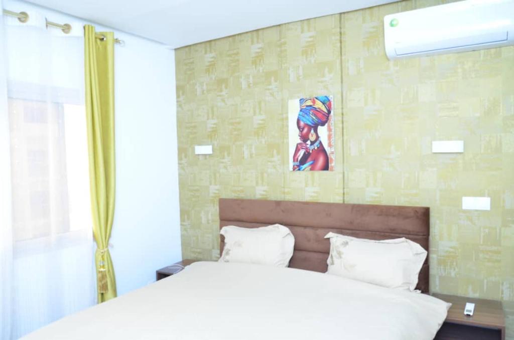 a bedroom with a bed and a painting on the wall at F3 Dakar Plateau Appartement Cité Emmergence in Dakar