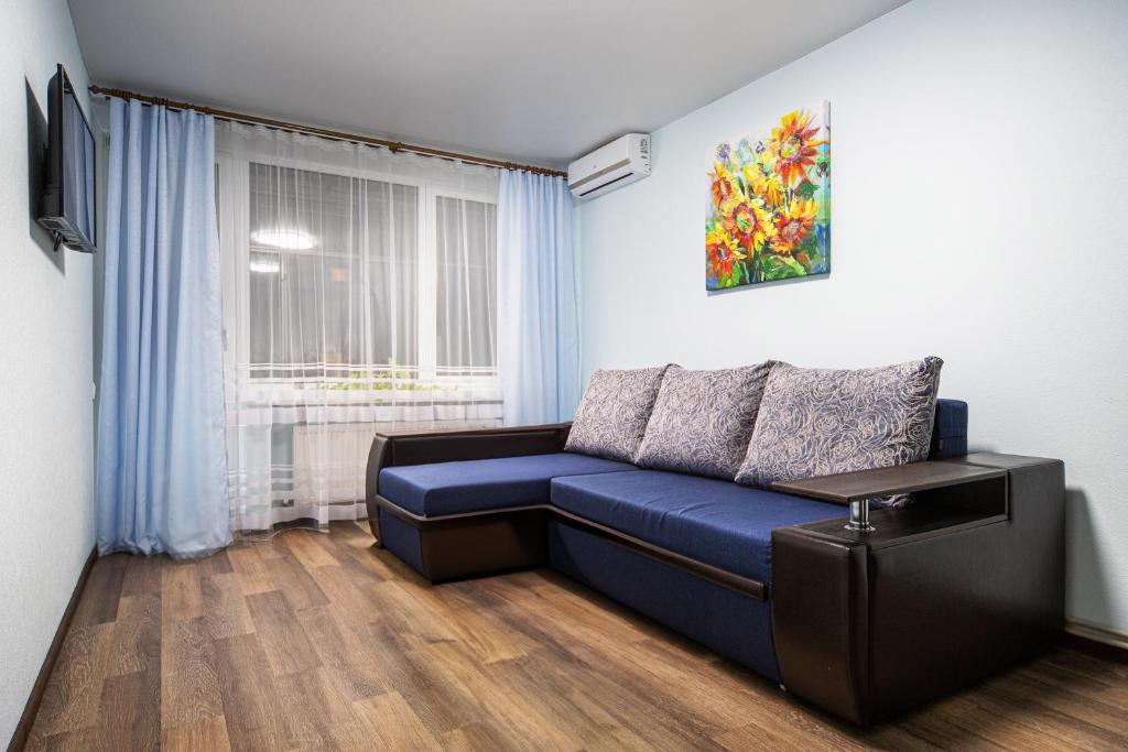 uma sala de estar com um sofá azul e uma janela em Central Park Apartment em Lviv