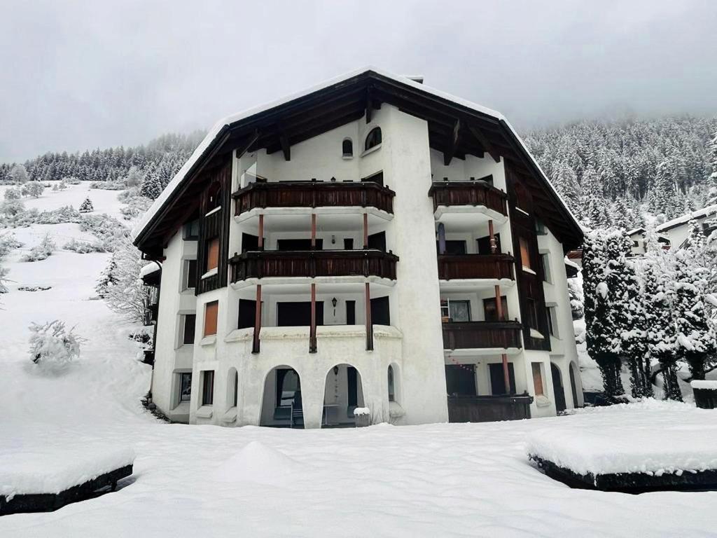 a large apartment building with snow on the ground at Cadras in Tinzen