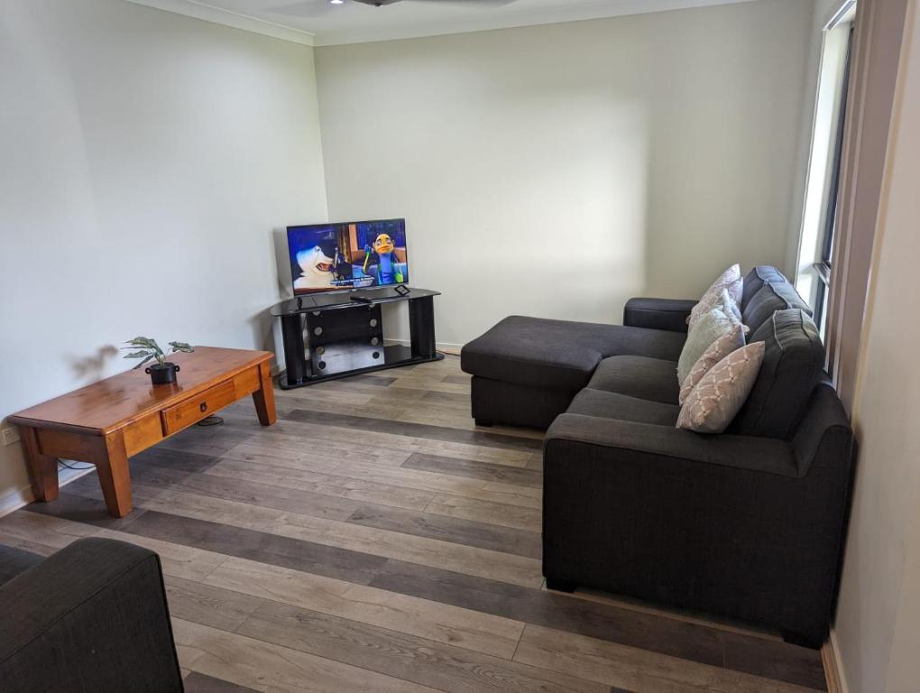ein Wohnzimmer mit einem Sofa und einem Couchtisch in der Unterkunft Gladstone Entire House 4 Beds 2 Baths Air-conditioned in City in Beecher