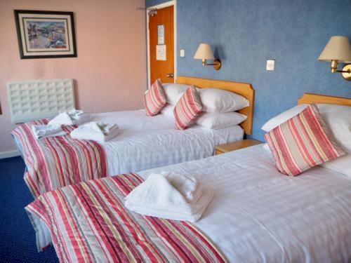 a hotel room with two beds with towels on them at Devon Towers Hotel in Bournemouth