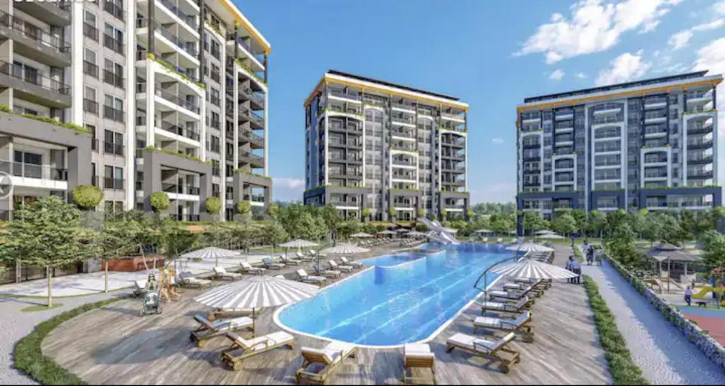 an image of a swimming pool with two tall buildings at Emerald Paradise Apartment in Avsallar