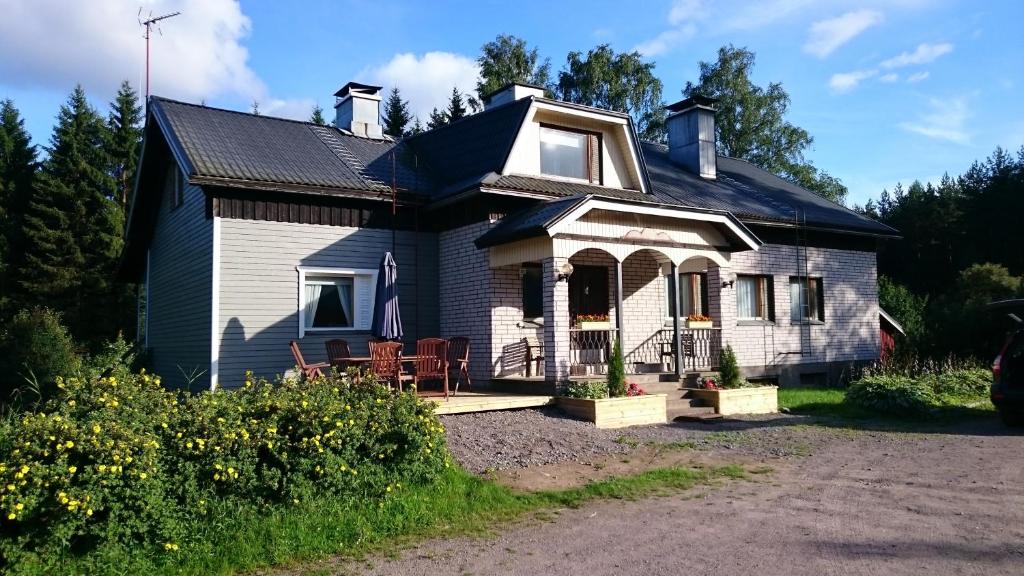 a white house with a black roof at Metsäniityn Tuvat in Billnäs