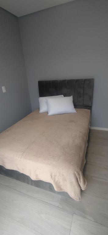 a bedroom with a bed with a blanket on it at Sobrado em Piçarras com piscina in Piçarras