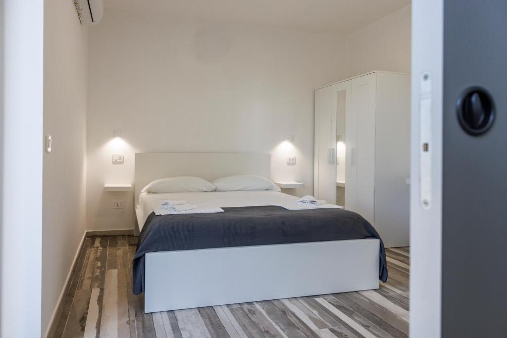 a white bedroom with a bed and two lamps at Essentia Rooms & Relax in Vasto