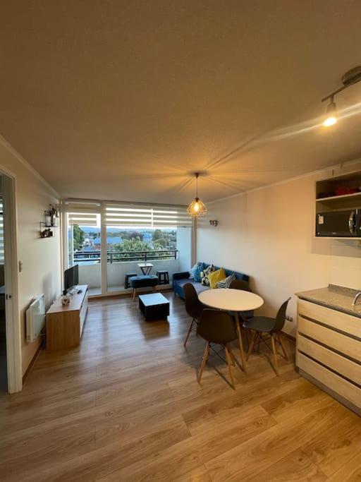 a living room with a table and a couch at Departamento céntrico in Valdivia