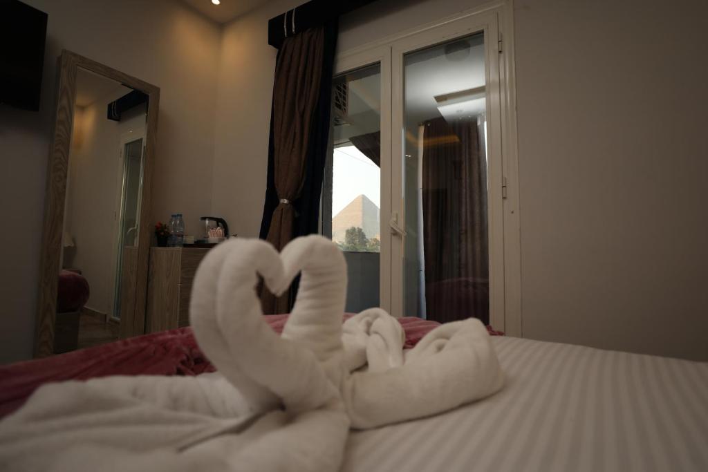 Postel nebo postele na pokoji v ubytování Capital Of Pyramids Hotel