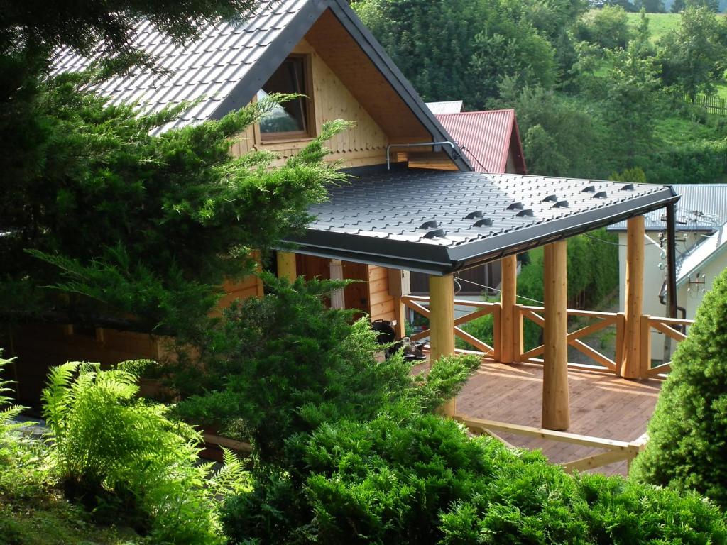 une maison avec un toit en métal sur une terrasse dans l'établissement Domek w Gorcach, à Ochotnica Dolna