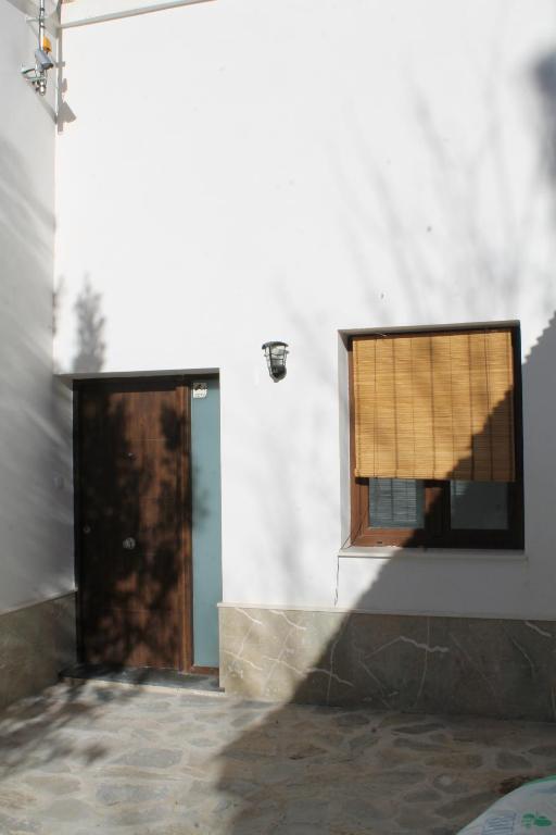 eine Tür und ein Fenster in einem weißen Gebäude in der Unterkunft CASTILLO CARAVACA PRINCIPAL in Caravaca de la Cruz