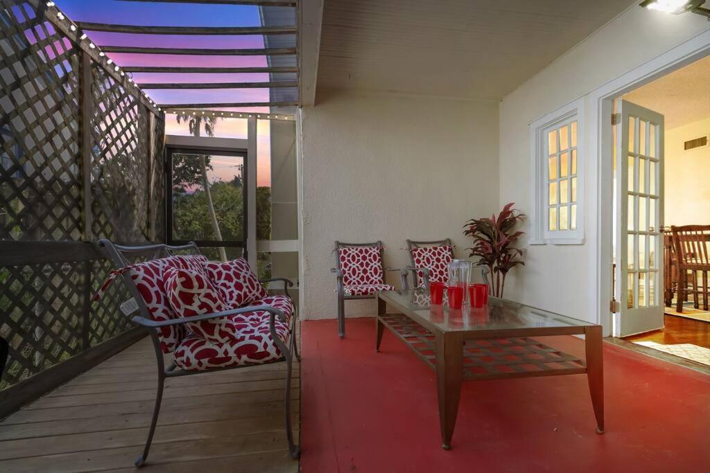 a patio with a table and chairs on a porch at Beautiful Home Steps from the beach + Side Porch in Daytona Beach