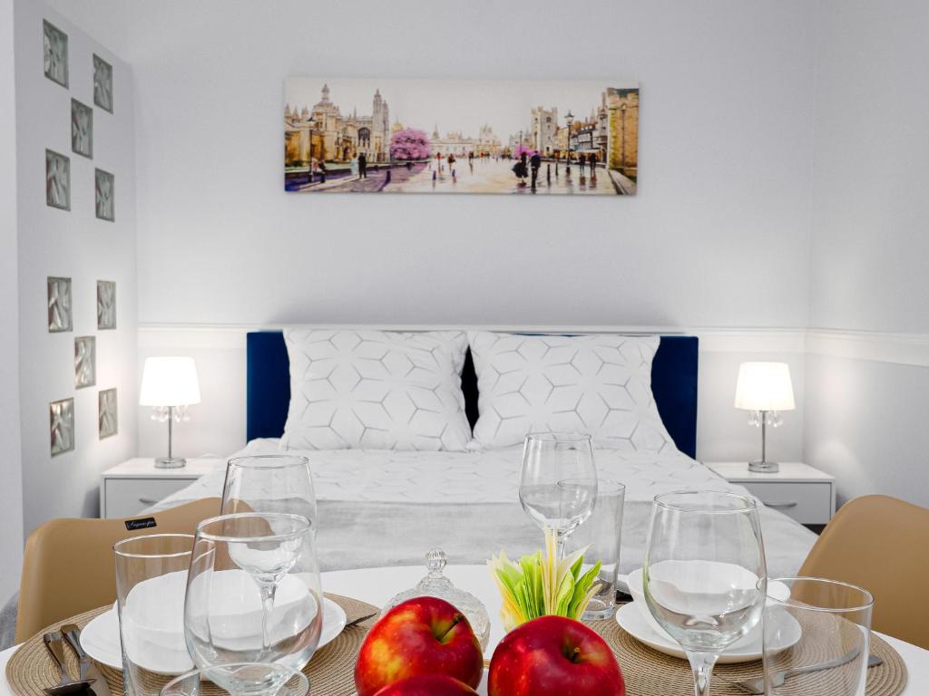 a dining room with a table with apples and glasses at Apartament Greta in Złoty Stok