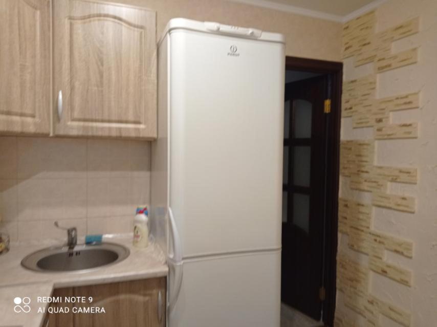 a white refrigerator in a kitchen with a sink at Автовокзал Apartaments 2kv in Dnipro