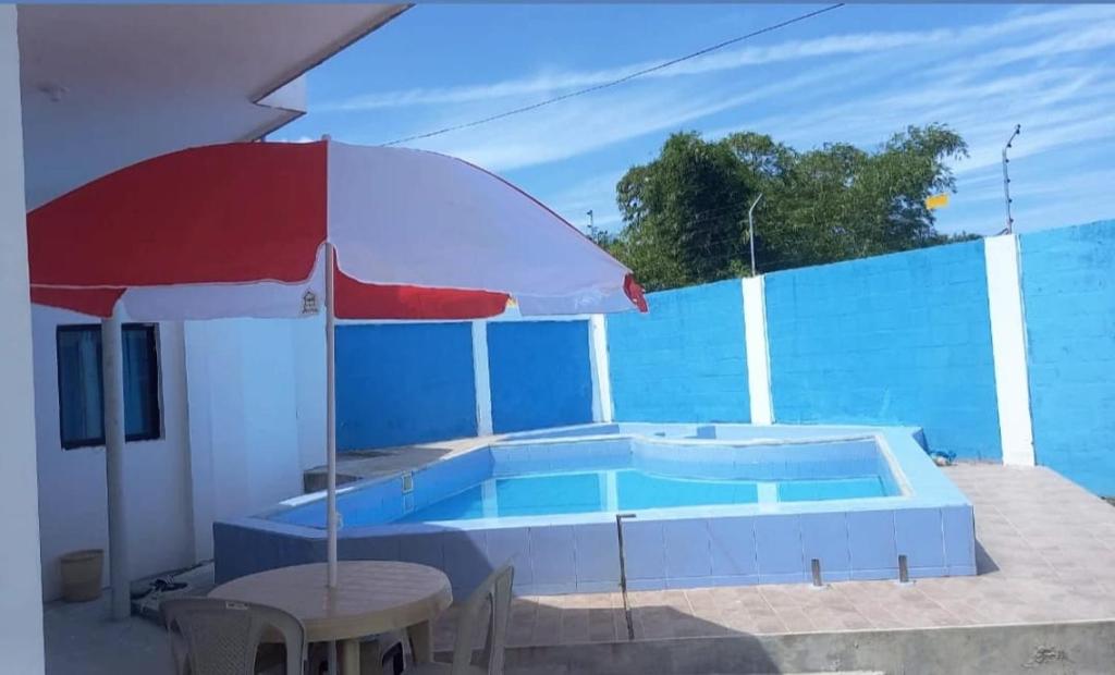 a pool with a table and an umbrella and a table and an umbrella at Casa Tonsupa in Tonsupa