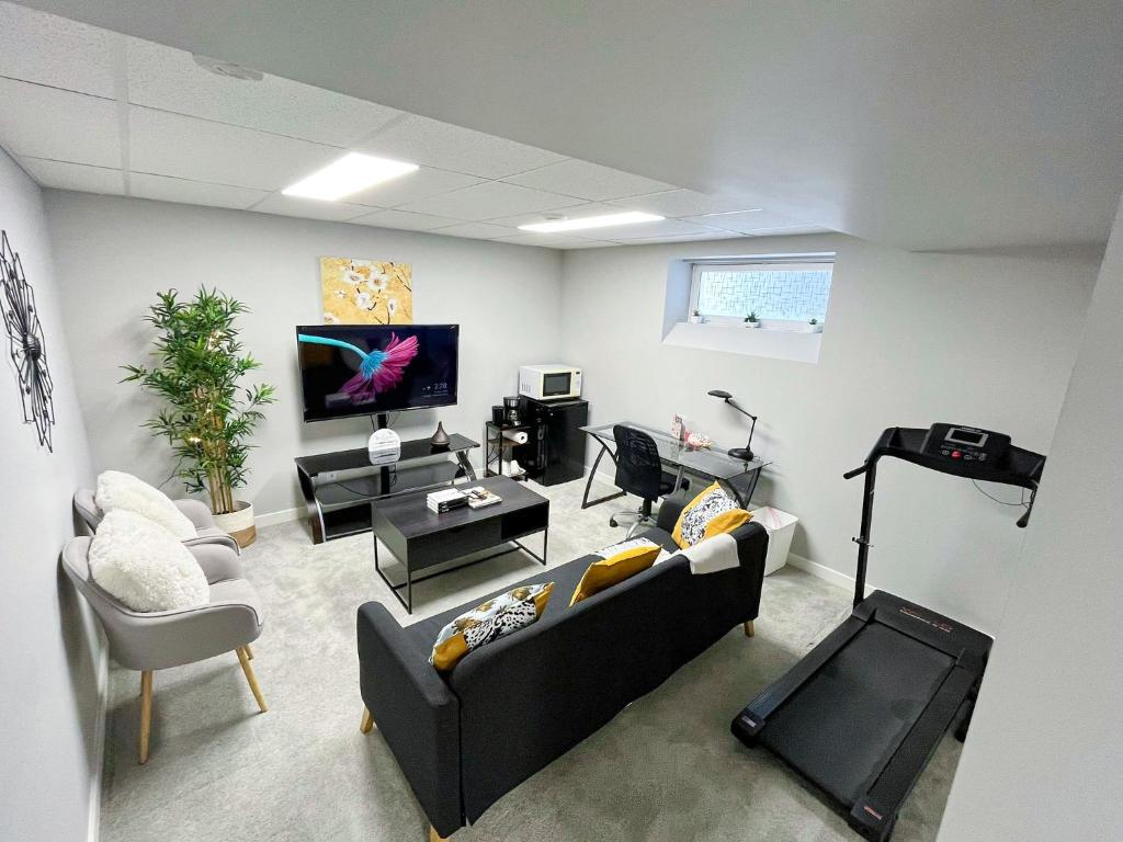 a living room with a couch and a tv at Stylish Basement Suite with Modern Comforts in Winnipeg