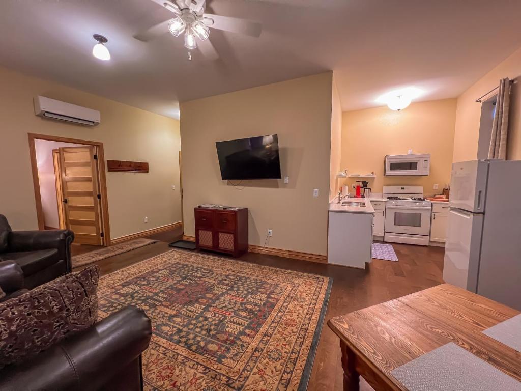 een woonkamer met een bank en een tv aan de muur bij Goldfinch Suites in Elkader