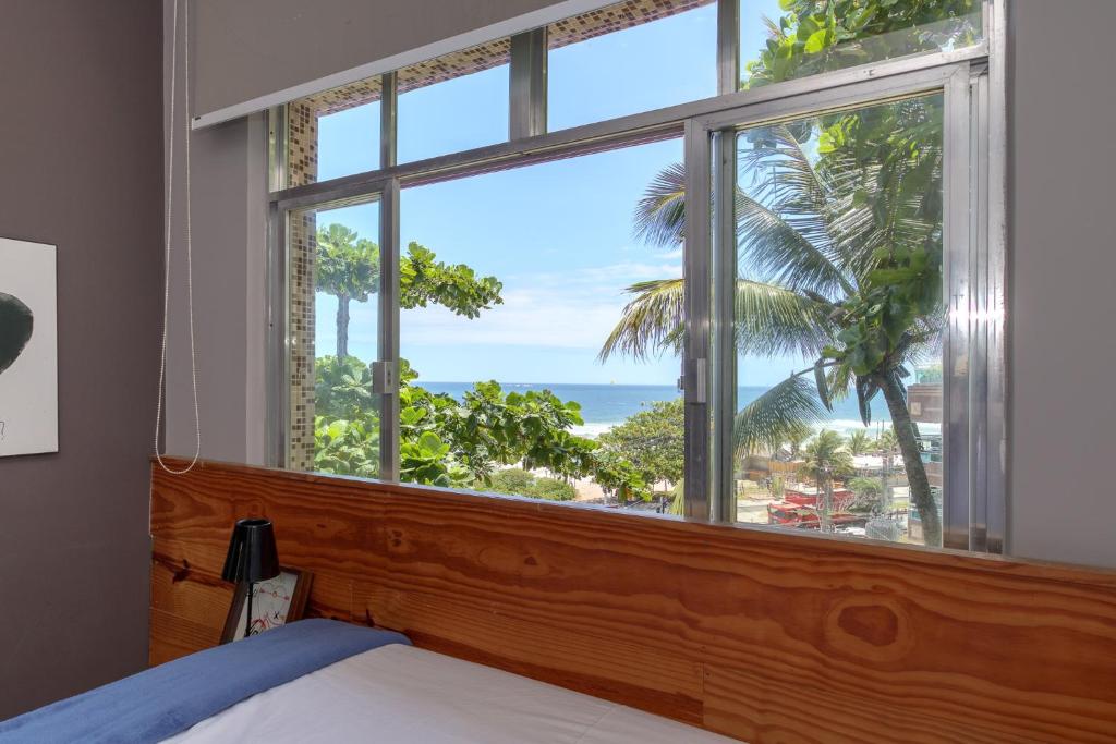 a bedroom with a window with a view of the ocean at Studio Oceanview in Rio de Janeiro