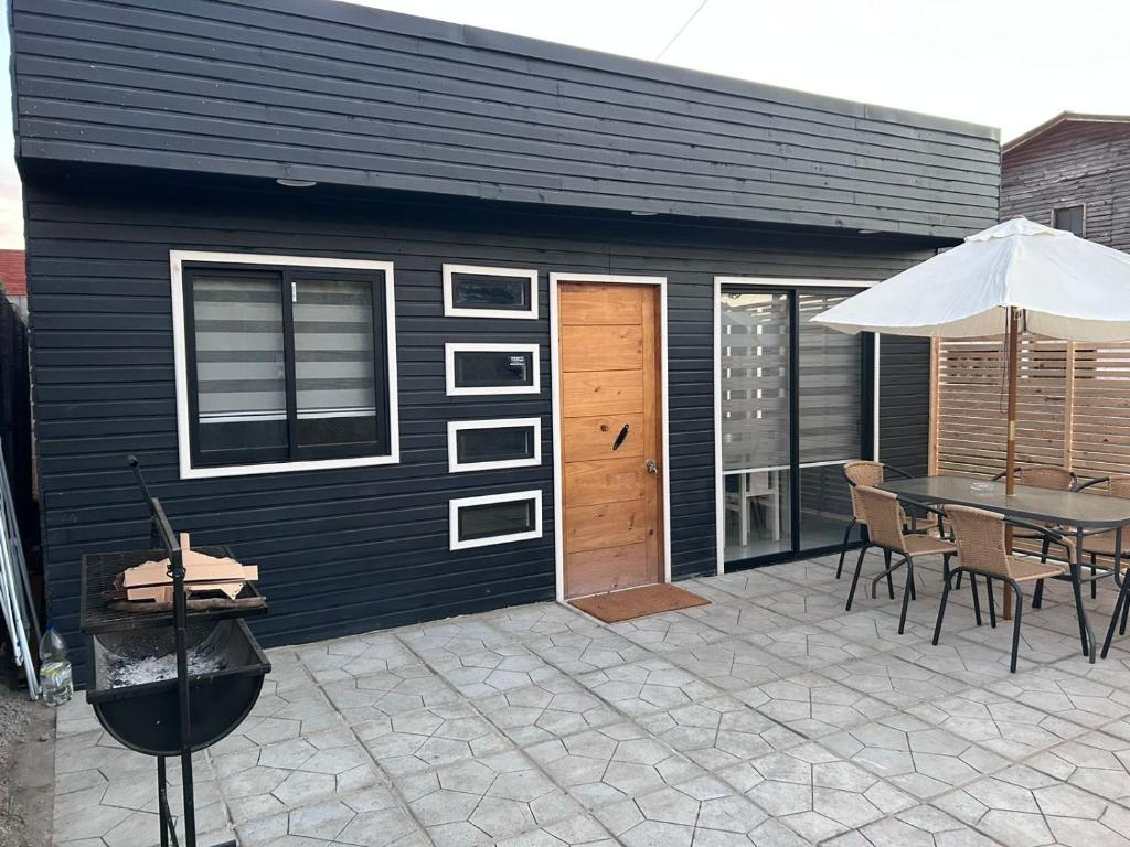 eine Terrasse mit einem Tisch und einem Sonnenschirm in der Unterkunft Casas el Quisco norte in El Quisco