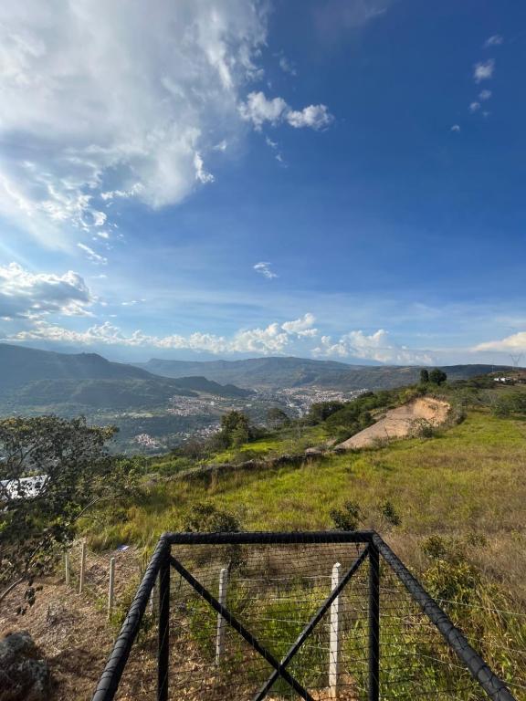 Aussicht von der Spitze eines Hügels mit einem Zaun in der Unterkunft Mirador Villa Natalia in San Gil