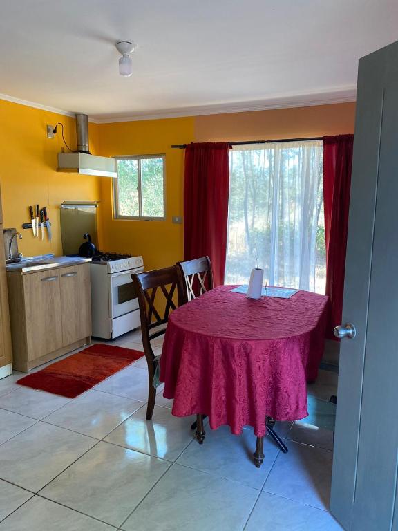 a kitchen with a table with a purple table cloth at casita de campo in Chillán