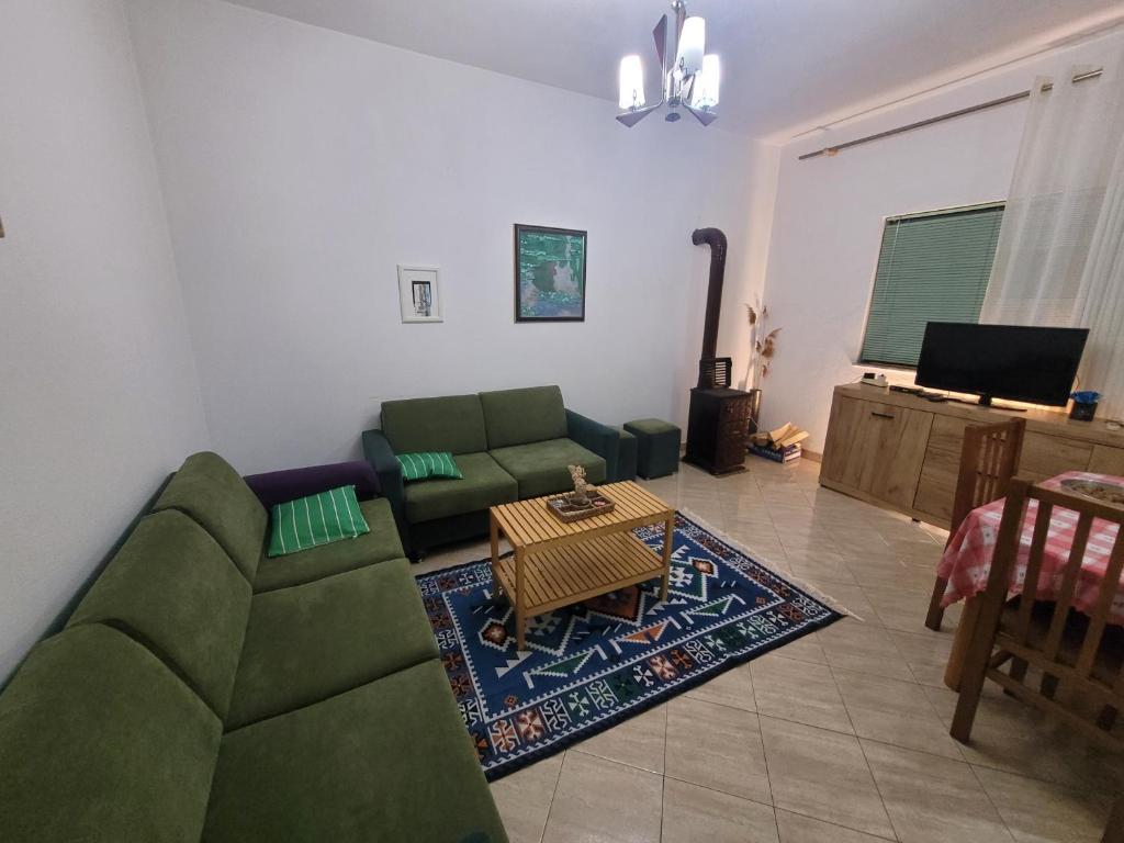 a living room with a green couch and a table at Garden house in Kashari