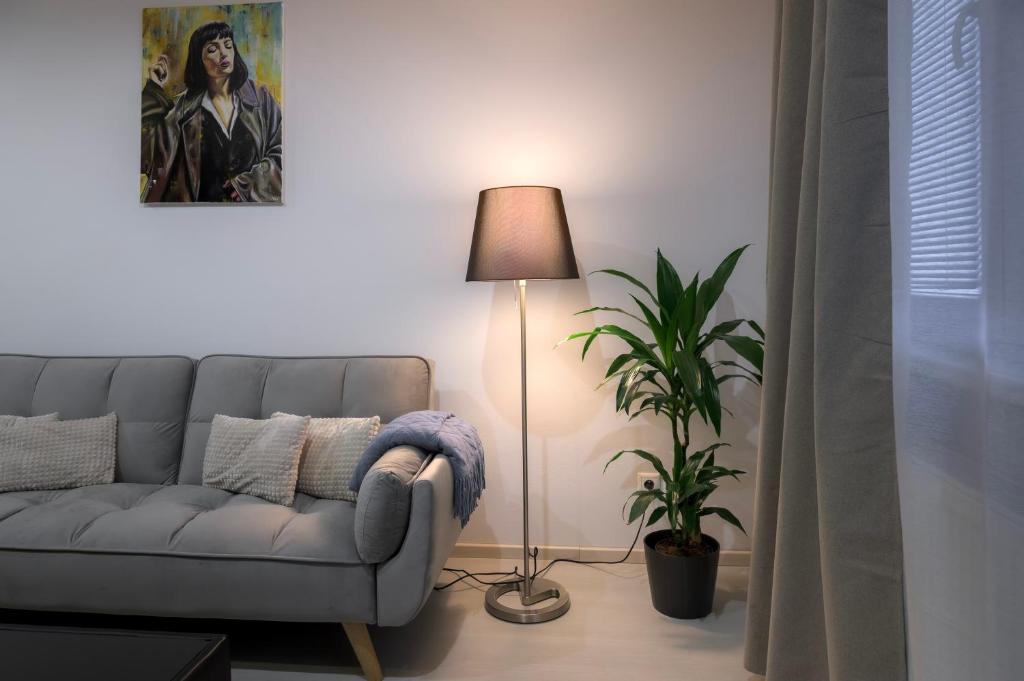 uma sala de estar com um sofá e um candeeiro em Apartmán Štefánik #1 em Martin