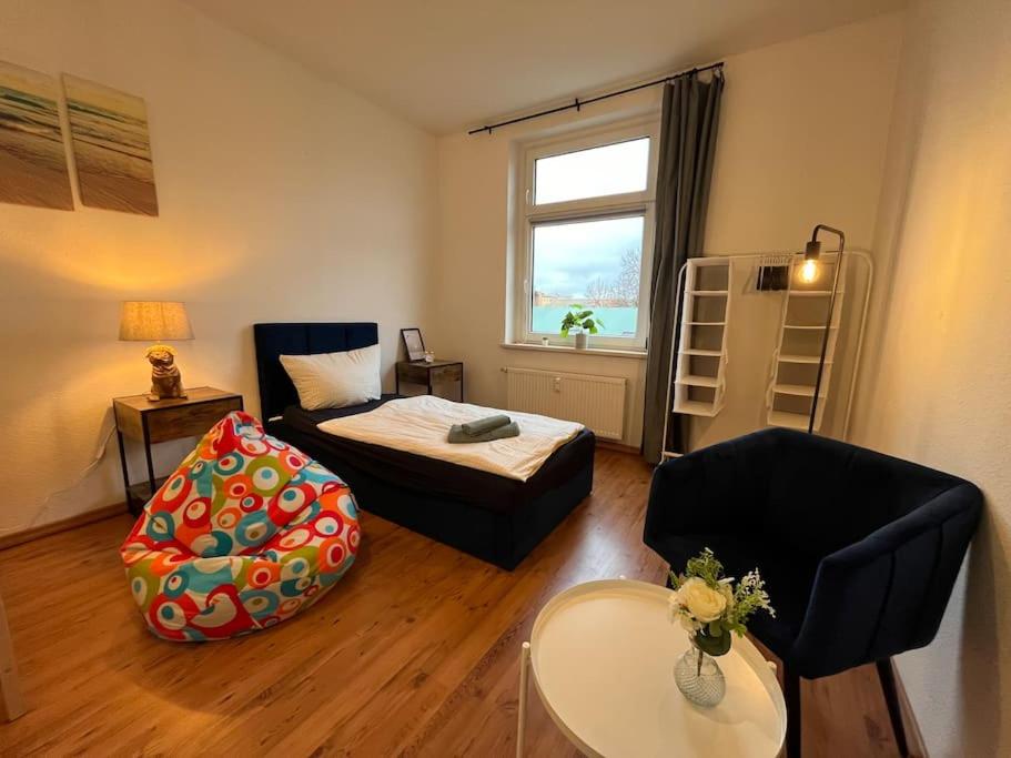 ein Wohnzimmer mit einem Bett und einem Stuhl in der Unterkunft 00 - BlueChili Apart - Moderne Familienwohnung, Top Lage Stylisch in Magdeburg