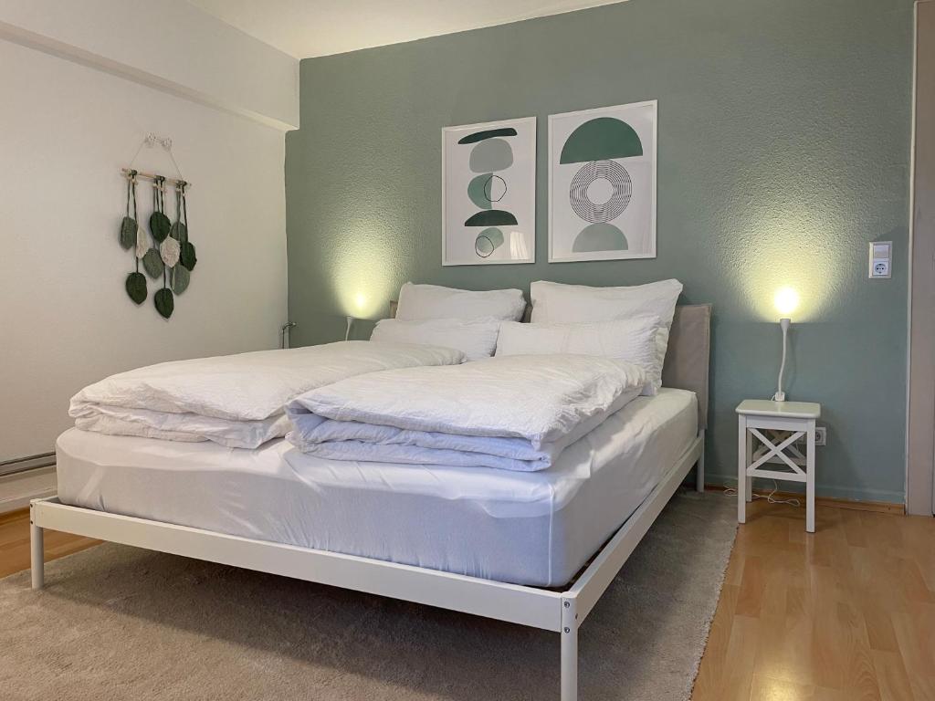 1 cama con sábanas blancas y almohadas en una habitación en Wohnung mit 3 Schlafzimmern, Dachterrasse und Flussblick, en Ühlingen-Birkendorf