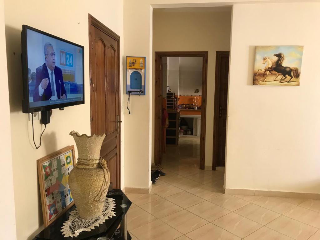 a living room with a television and a vase on a table at Appartement Familial a 3min de la gare routiere Tanger in Tangier