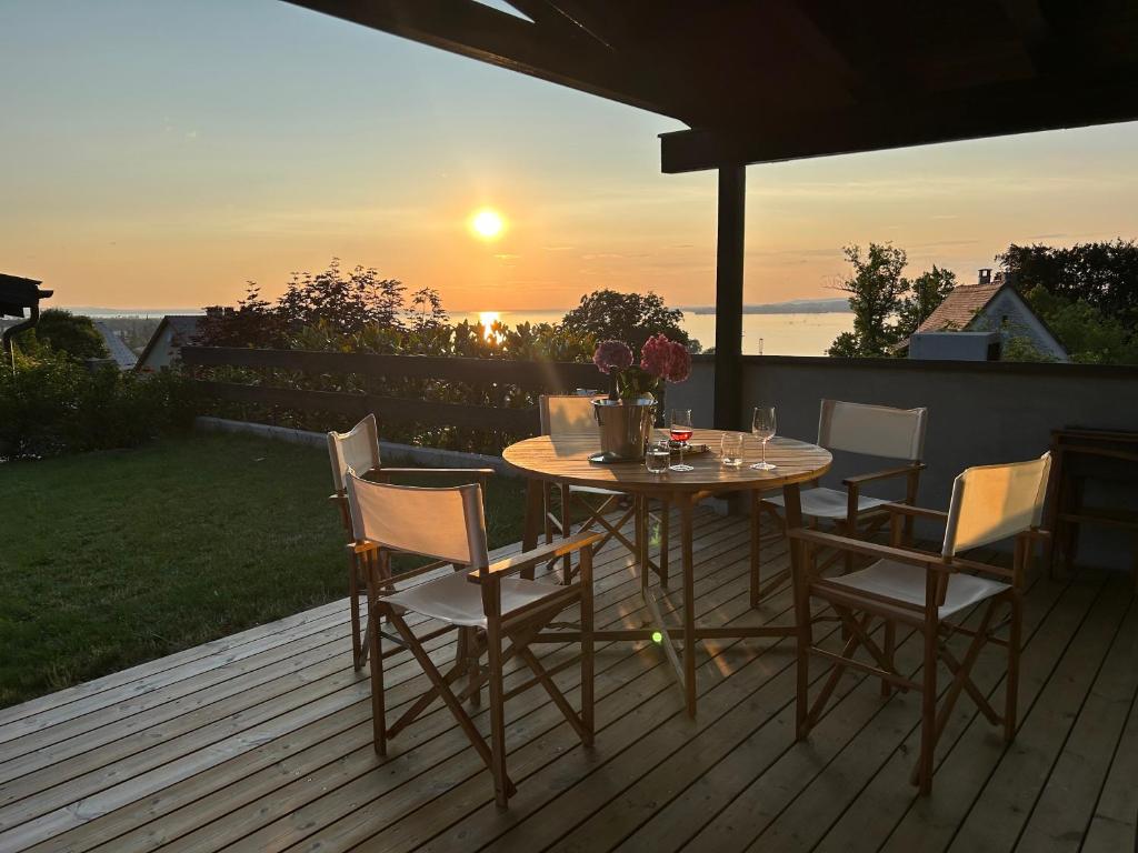 a table and chairs on a deck with the sunset at HAUS A Ankommen*Abschalten*Auftanken in Bregenz