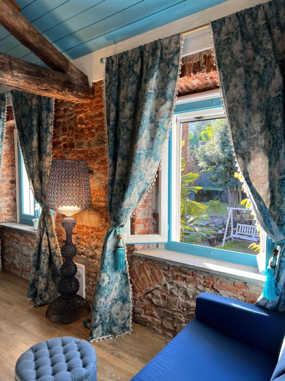 a living room with a blue couch and a window at Il Giardino Segreto Arona, Charming Apartments in Arona