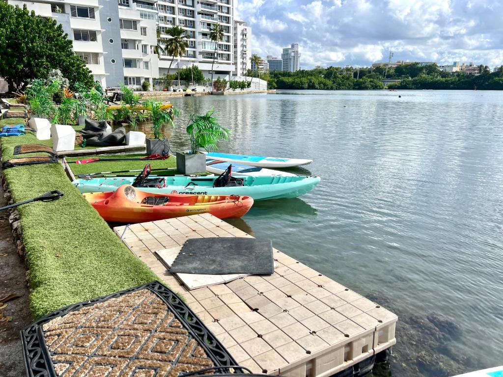 a group of kayaks on the water next to a dock at Condado Beachfront Tantra Apartment in San Juan