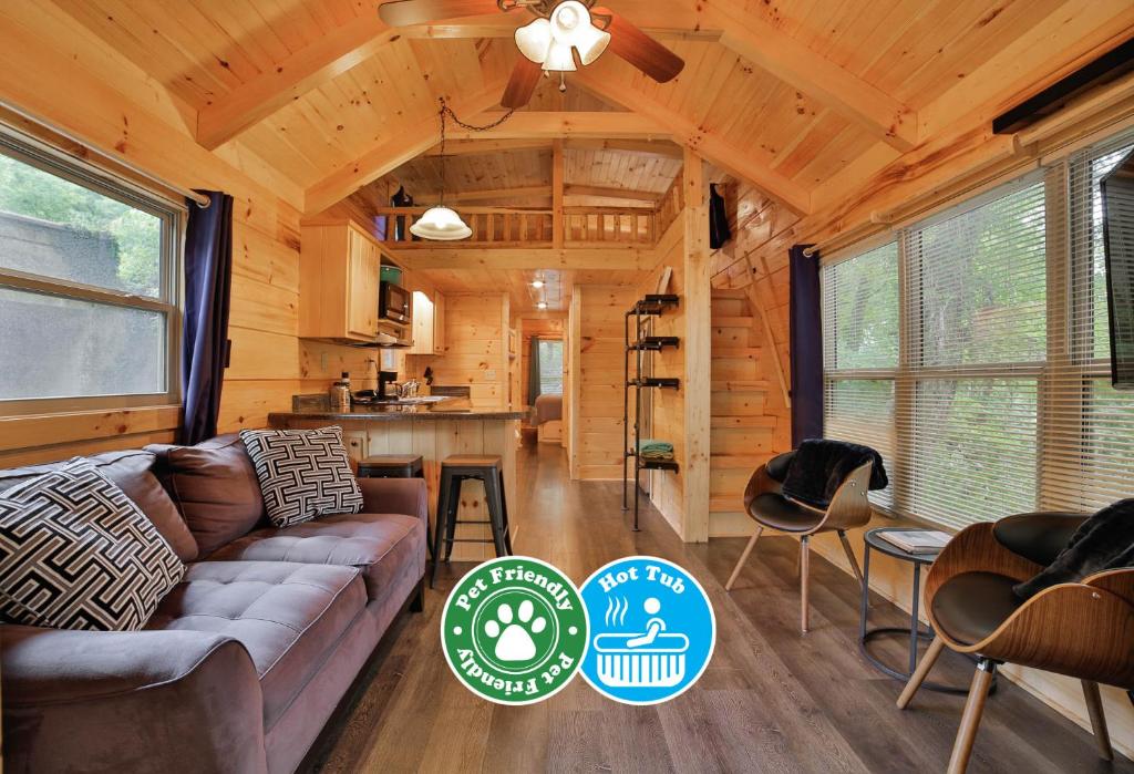 una sala de estar con sofá en una cabaña de madera en Thomas Cabin Forest Tiny Cabin With Hot Tub en Chattanooga