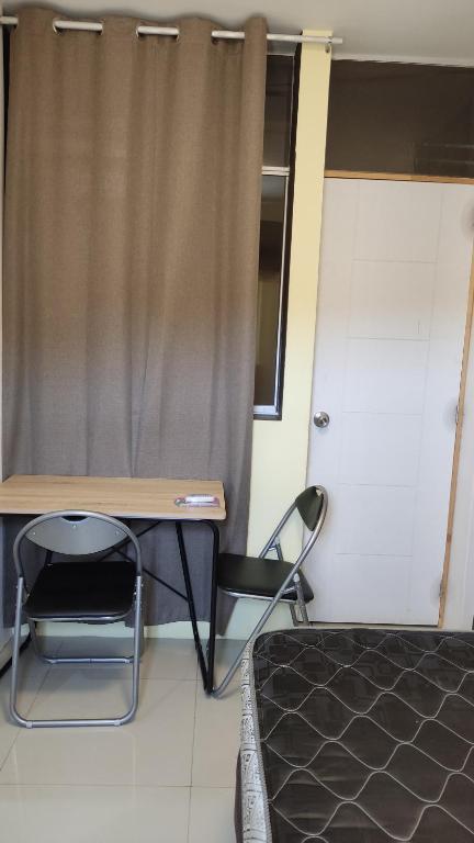 塔拉拉的住宿－Condominio confortable，一间卧室配有一张床、一张桌子和一把椅子