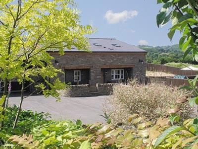 a large brick house in the middle of a garden at Mouse Castle Barn in Hay-on-Wye