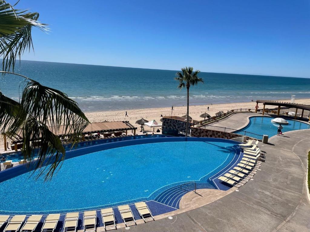 a large swimming pool next to a beach at Sonoran Sky Resort Vista a Playa Azul in Puerto Peñasco