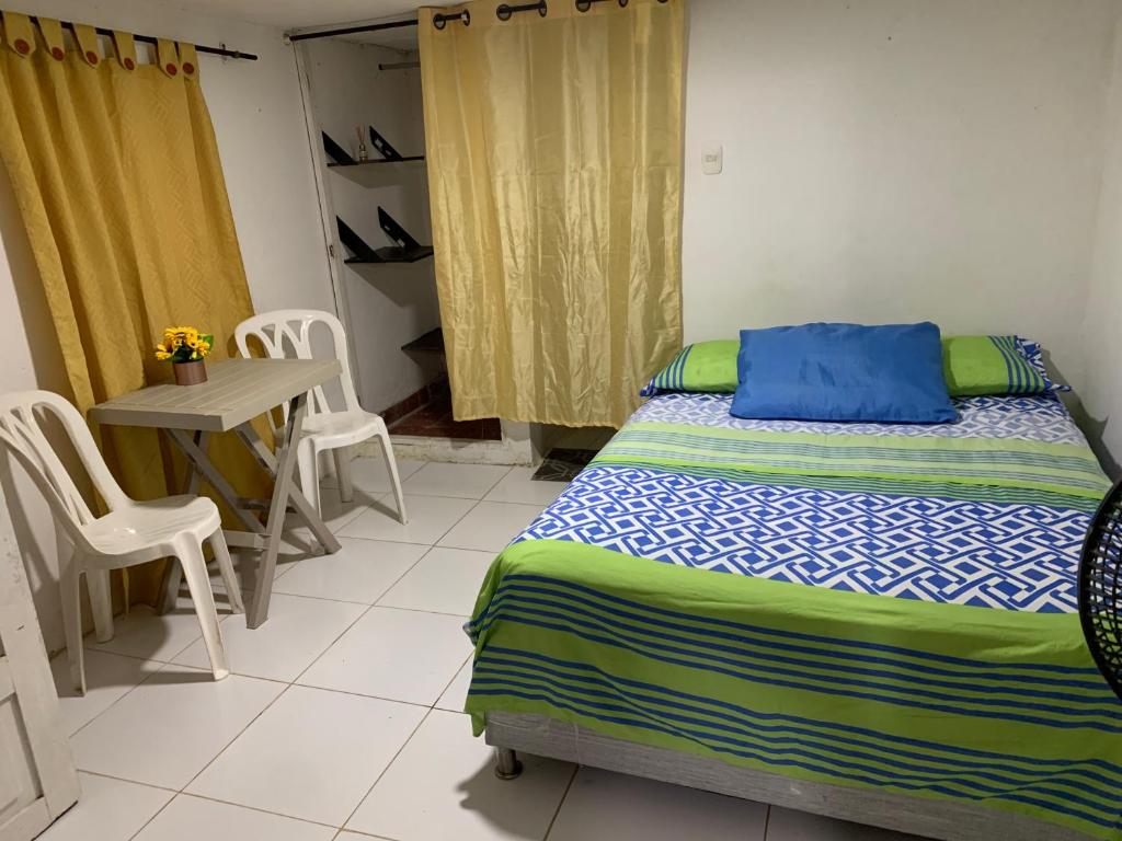 a bedroom with a bed and a table and chairs at Habitación independiente cerca al mar. in Puerto Salgar