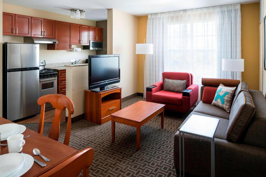 a living room with a couch and a tv and a kitchen at TownePlace Suites Milpitas Silicon Valley in Milpitas