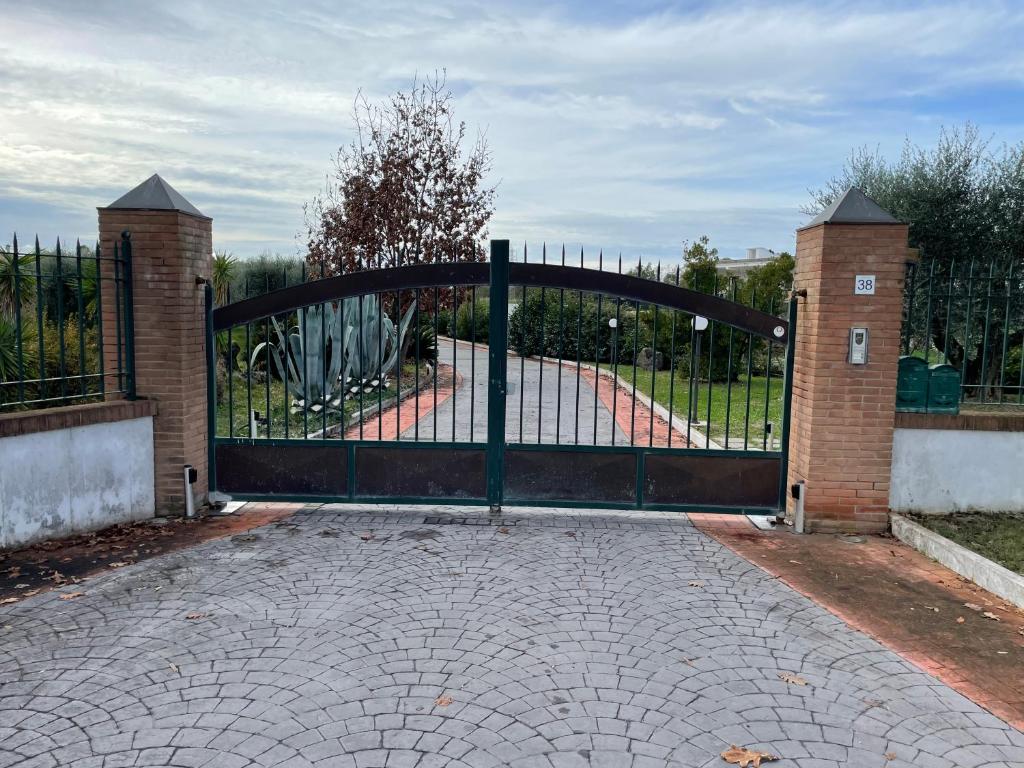 un cancello aperto con recinzione di mattoni e metalli di A Casa Di Gigi a Latina