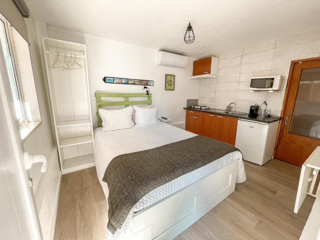 um pequeno quarto com uma cama e uma cozinha em Little Place Nazaré na Nazaré