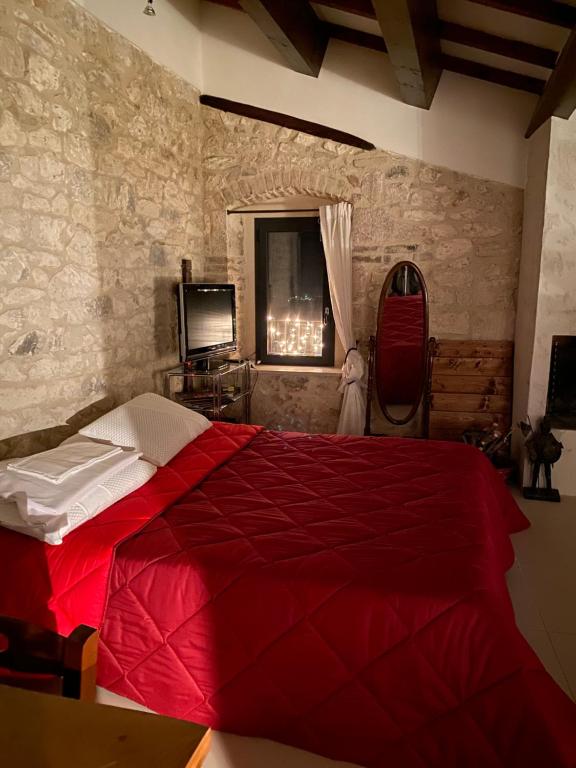 a bedroom with a red bed and a window at B&B San Nicola in Pretoro