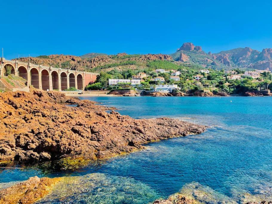 un pont sur une étendue d'eau avec des montagnes en arrière-plan dans l'établissement Vue exceptionnelle - 4 pers. jardin clim parking, à Saint-Raphaël