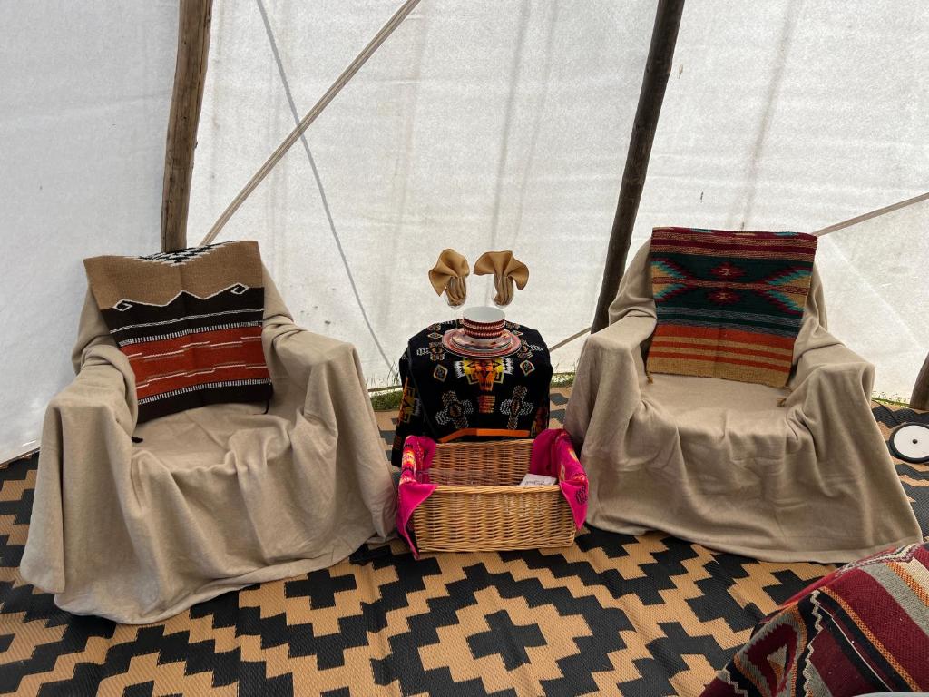 twee stoelen en een knuffeldier in een tent bij JMA Tipi in Riverton